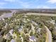 Picturesque aerial view of a residential area featuring mature trees, a pond, and waterfront access in the distance at 1828 S James Gregarie Rd, Mount Pleasant, SC 29466
