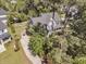 An aerial shot showcases a home with a driveway, basketball hoop, garden, and surrounding mature trees at 1828 S James Gregarie Rd, Mount Pleasant, SC 29466