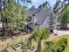Aerial view of backyard with a vegetable garden, basketball court, screened in porch, and mature trees at 1828 S James Gregarie Rd, Mount Pleasant, SC 29466