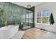 Spa-like bathroom featuring a soaking tub and glass-enclosed shower with green tiling at 1828 S James Gregarie Rd, Mount Pleasant, SC 29466