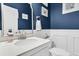 Stylish powder room with blue walls, a vanity with stone top, and an elegant mirror at 1828 S James Gregarie Rd, Mount Pleasant, SC 29466