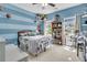 Bright bedroom with large window, blue walls with white stripe, and bookshelf full of books and decor at 1828 S James Gregarie Rd, Mount Pleasant, SC 29466