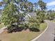 An exterior view of a home surrounded by mature trees and lush greenery, showcasing its serene setting at 1828 S James Gregarie Rd, Mount Pleasant, SC 29466