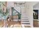 Inviting foyer featuring hardwood floors, a staircase, and stylish décor creating a warm and elegant entry at 1828 S James Gregarie Rd, Mount Pleasant, SC 29466