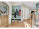 A welcoming foyer features hardwood floors, a coat rack with bench, and a glass paned front door at 1828 S James Gregarie Rd, Mount Pleasant, SC 29466