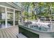 Outdoor hot tub on a wooden deck with a screened-in porch and a view of the trees at 1828 S James Gregarie Rd, Mount Pleasant, SC 29466
