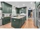 Modern kitchen showcasing dark green cabinets, stainless steel appliances, granite countertops and hardwood flooring at 1828 S James Gregarie Rd, Mount Pleasant, SC 29466