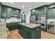 Elegant kitchen with dark green cabinets, granite countertops, stainless steel appliances, and a functional center island at 1828 S James Gregarie Rd, Mount Pleasant, SC 29466