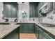 Modern kitchen featuring dark green cabinets, granite countertops, stainless steel appliances, and hardwood flooring at 1828 S James Gregarie Rd, Mount Pleasant, SC 29466