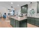 Spacious kitchen with dark green cabinets, a central island with granite countertops, and stainless steel appliances at 1828 S James Gregarie Rd, Mount Pleasant, SC 29466
