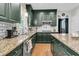 Beautiful kitchen featuring dark green cabinets, granite countertops, stainless steel appliances, and hardwood floors at 1828 S James Gregarie Rd, Mount Pleasant, SC 29466