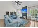 Cozy living room featuring a plush sectional sofa, fireplace with mounted TV, and large windows at 1828 S James Gregarie Rd, Mount Pleasant, SC 29466
