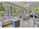 Relaxing screened porch with outdoor furniture, wooden floors and view of the surrounding trees at 1828 S James Gregarie Rd, Mount Pleasant, SC 29466