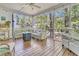 Relaxing screened porch with outdoor furniture, wooden floors and view of the surrounding trees at 1828 S James Gregarie Rd, Mount Pleasant, SC 29466