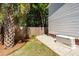Lush backyard featuring a well-maintained lawn, palm tree, and a convenient generator at 2001 Baltusrol Ct, Summerville, SC 29483