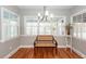 Bright dining area featuring wood floors, a charming bench, and large windows with plantation shutters at 2001 Baltusrol Ct, Summerville, SC 29483