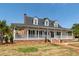 Beautiful white traditional-style home with a large wrap-around porch and well-kept landscaping at 2001 Baltusrol Ct, Summerville, SC 29483