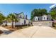 Charming white home with a detached garage, featuring a brick chimney and landscaped yard at 2001 Baltusrol Ct, Summerville, SC 29483