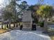 Outdoor brick fireplace featuring a brick patio and decorative palms, creating a cozy entertaining space at 2001 Baltusrol Ct, Summerville, SC 29483