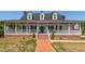 Charming home featuring a welcoming covered front porch, brick stairs, and a brick foundation at 2001 Baltusrol Ct, Summerville, SC 29483