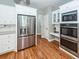 Kitchen with stainless refrigerator and oven, granite countertops, white cabinets and hardwood floors at 2001 Baltusrol Ct, Summerville, SC 29483