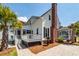 Charming white home featuring a brick chimney, screened-in porch, and landscaped patio area for outdoor enjoyment at 2001 Baltusrol Ct, Summerville, SC 29483