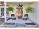 Inviting front porch with comfortable seating, hanging ferns, and decorative front door at 2021 Beckton St, North Charleston, SC 29420