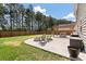 Landscaped backyard with a stone patio, fire pit, dining pergola, and wooded perimeter for privacy at 210 Witch Hazel St, Summerville, SC 29486