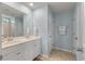 Well-lit bathroom with double vanity, tile flooring, framed mirrors, and a glass-enclosed shower at 210 Witch Hazel St, Summerville, SC 29486