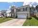 Two-story home with stone accents, white garage door, and manicured lawn at 210 Witch Hazel St, Summerville, SC 29486