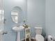 Powder room features pedestal sink, wood-look flooring and refreshing blue paint at 210 Witch Hazel St, Summerville, SC 29486