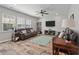 Hard floored living room with two leather sofas, large windows, ceiling fan, and mounted TV at 210 Witch Hazel St, Summerville, SC 29486