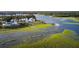Stunning aerial view showcasing waterfront property with houses, a dock, and kayaks exploring the waterway at 2138 Boatwright Rd, Johns Island, SC 29455