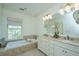 Bright bathroom featuring a double vanity, soaking tub, and neutral tile floors at 22 Fairhope Rd, Mount Pleasant, SC 29464