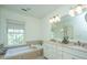 Bright bathroom featuring a double vanity, soaking tub, and neutral tile floors at 22 Fairhope Rd, Mount Pleasant, SC 29464