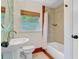 Charming bathroom with tiled shower and floors, pedestal sink, and tropical-themed wallpaper at 238 Howle Ave, Charleston, SC 29412