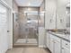 Bright bathroom featuring a tiled shower with a glass door, granite countertop, and neutral tile flooring at 245 Ribbon Rd, Summerville, SC 29483