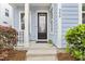 Close-up of the home's entry featuring a black door, stylish address numbers, and healthy green plants at 245 Ribbon Rd, Summerville, SC 29483