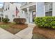 Inviting home entrance with a black front door, manicured bushes, and an American flag displayed at 245 Ribbon Rd, Summerville, SC 29483
