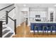 Modern kitchen island with counter seating next to a staircase with beautiful wood floors at 245 Ribbon Rd, Summerville, SC 29483
