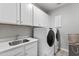 Modern laundry room with washer, dryer, and plenty of storage cabinets at 245 Ribbon Rd, Summerville, SC 29483