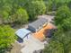 Aerial view of home with a detached garage, surrounded by lush green forest and open sky at 254 Nelson Farm Ln, Cross, SC 29436