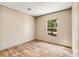 Bright bedroom featuring wood-look floors, neutral walls, and a window with a view of the outdoors at 254 Nelson Farm Ln, Cross, SC 29436