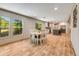 Bright dining area with wood-look floors flowing into an open kitchen with stainless steel appliances and an island at 254 Nelson Farm Ln, Cross, SC 29436
