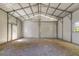 Spacious two-car garage interior with bright, white metal walls and a gravel floor at 254 Nelson Farm Ln, Cross, SC 29436