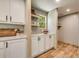 Bright kitchenette area features white cabinets, stainless steel hardware, tile backsplash, and open shelving at 254 Nelson Farm Ln, Cross, SC 29436
