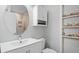 Bathroom with white vanity, circular mirror, toilet, and tile-surround shower at 2766 Old Oak Walk, Seabrook Island, SC 29455