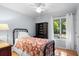 Cozy bedroom with hardwood floors, ceiling fan, black metal bed frame, and natural light from the window at 2766 Old Oak Walk, Seabrook Island, SC 29455