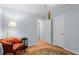 Bedroom with hardwood floors, open doorway, red chair, and area rug at 2766 Old Oak Walk, Seabrook Island, SC 29455