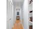 Hallway with hardwood floors, ample storage with built-in shelves and multiple closet doors at 2766 Old Oak Walk, Seabrook Island, SC 29455